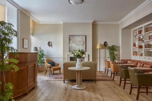 a waiting room with chairs and a table with flowers at Miiro Templeton Garden in London
