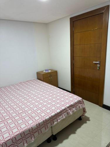a bedroom with a bed and a wooden door at Casa em Guarapari in Guarapari