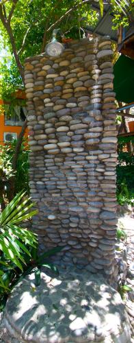 a large stone wall in a yard at Tico Adventure Lodge in Sámara