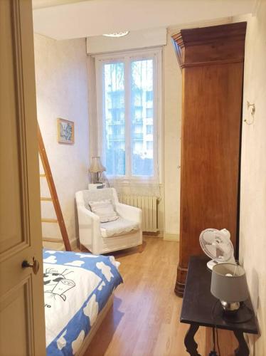 une chambre avec un lit, une chaise et une fenêtre dans l'établissement Maison avec Jardin Terrasse Parking à 9 min centre, à Avignon