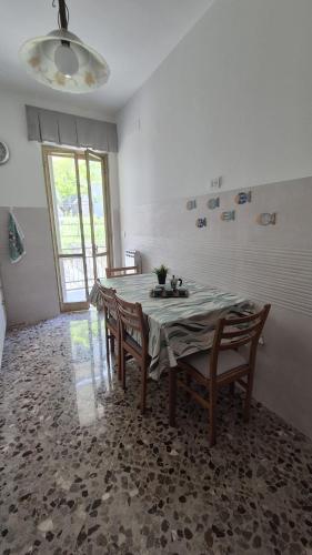 a dining room with a table and chairs and a window at Soffio Marino in Polignano a Mare