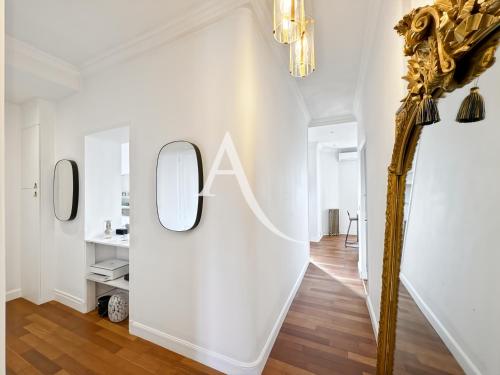 un couloir avec un mur blanc et un miroir dans l'établissement VRG4, à Cannes