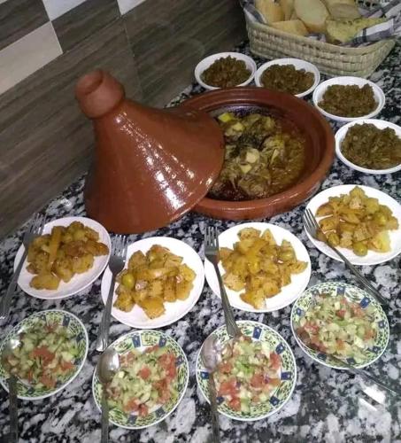 a table topped with plates of food and a vase at DAR Moha dades in Aït Ougliff