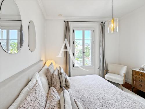 une chambre blanche avec un lit et une chaise dans l'établissement VRG4, à Cannes