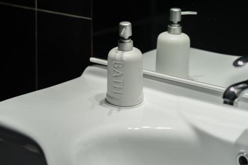 a white sink with a bottle of mouthwash in front of a mirror at Consi's House - ItalyWeGo in Torgiano