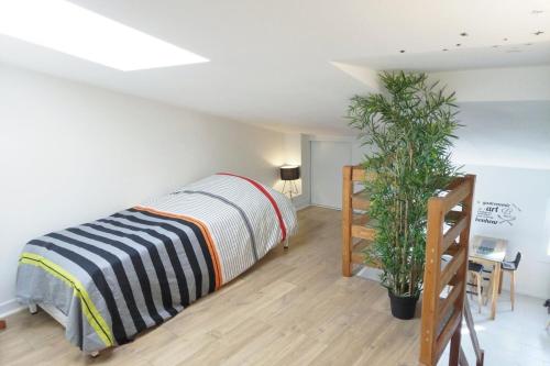 une chambre avec un lit et une plante en pot dans l'établissement Appartement au cœur de La Rochelle avec parking, à La Rochelle