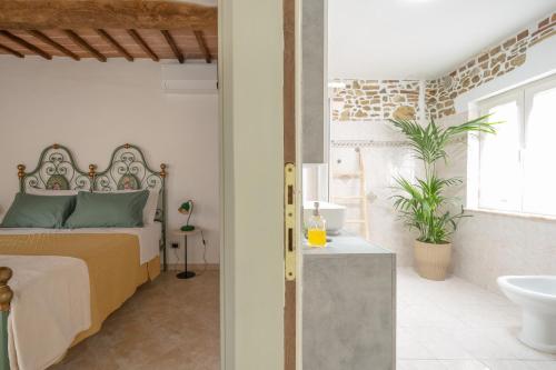 a bedroom with a bed and a bathroom with a sink at Consi's House - ItalyWeGo in Torgiano