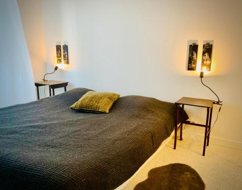 a bedroom with a bed and a table and two lamps at Les Sardinières in Le Relecq-Kerhuon