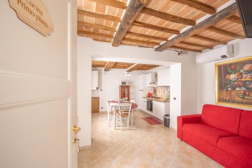 a living room with a red couch and a table at Consi's House - ItalyWeGo in Torgiano