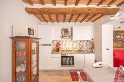 a kitchen with white cabinets and a microwave at Consi's House - ItalyWeGo in Torgiano