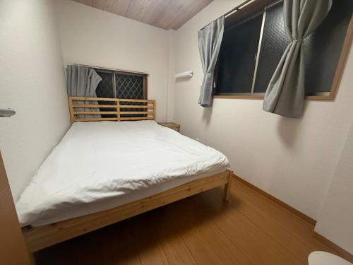 Wadaにある亀戸民泊2階ダブルベット2つの窓のある小さな部屋にある小さなベッド