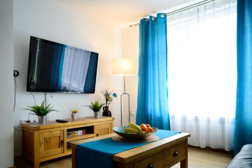 a living room with a tv and a bowl of fruit on a table at Modern house , Perfect for business trip & Families holiday or working proffesionals-5 min from M1 J25 , 500MB Wi-Fi , Netflix , Fully equiped kitchen , Asda supermarket 5 min walk , Free Secure parking with CCTV ,available monthly deals in Nottingham