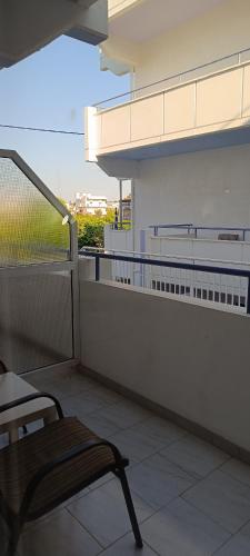 a chair sitting on a balcony with a view at Pyrgos Hotel Apartments in Kremasti