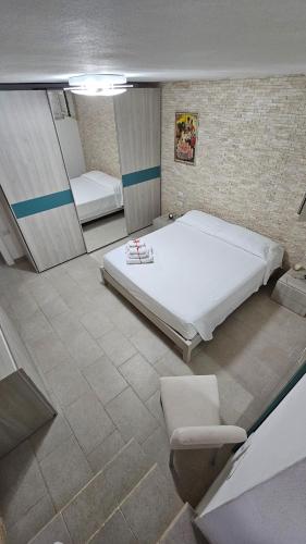 a bedroom with a large bed and a mirror at Calasetta, casa vista mare in Calasetta