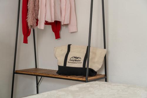 a clothes rack with a bag and clothes at Consi's House - ItalyWeGo in Torgiano
