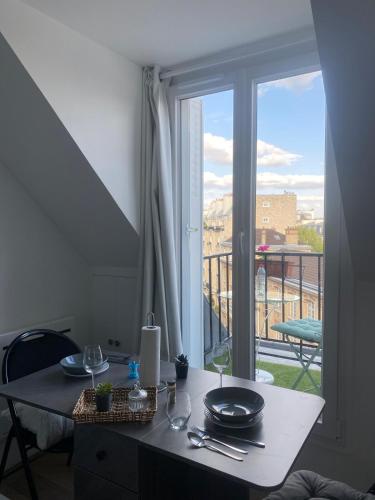 une table avec plaques devant une fenêtre dans l'établissement Loft de luxe à deux pas du panthéon, à Paris