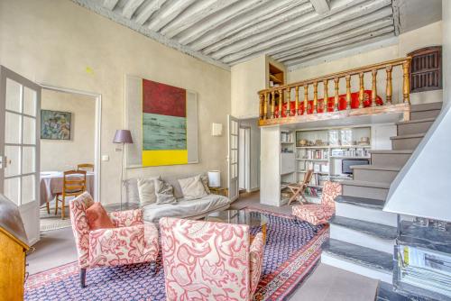 un salon avec un canapé et un escalier dans l'établissement Aquino, à Paris