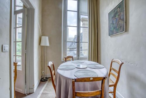 - une table avec des chaises dans une chambre avec une fenêtre dans l'établissement Aquino, à Paris