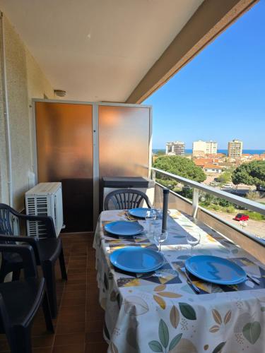 une salle à manger avec une table et des chaises et un balcon dans l'établissement Les Marines du Soleil Canet-Plage, à Canet
