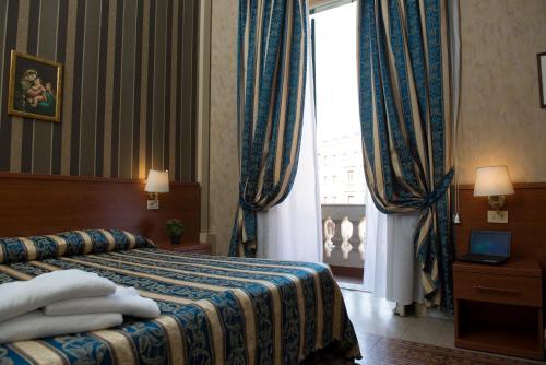 a hotel room with a bed and a window at Hotel Emmaus in Rome