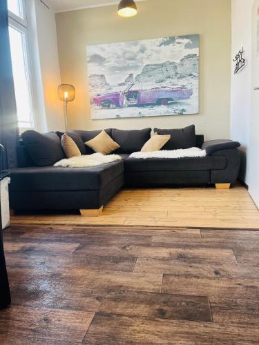 a blue couch in a living room with a wooden floor at Feldhouse in Bremen