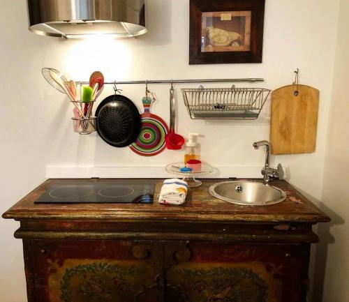 a kitchen counter with a sink and utensils on the wall at La Casetta sui tetti in Bergamo