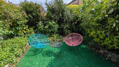 3 chaises assises sur l'herbe dans un jardin dans l'établissement STOCKHOLM- Studio Cosy et Patio, Proche Centre, à Charleville-Mézières