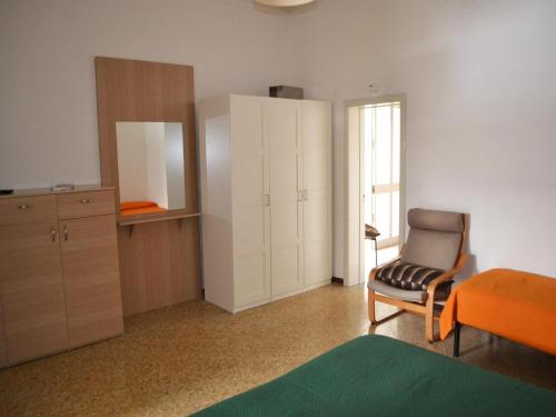 ein Schlafzimmer mit einem Stuhl und einem Schrank und einem Fenster in der Unterkunft TSUKY Holiday Home in Torre dellOrso in Torre dell'Orso