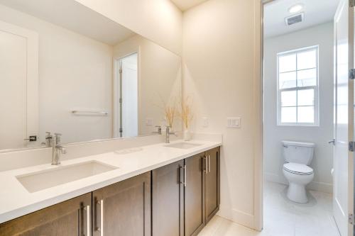 a bathroom with two sinks and a toilet at Pool Paradise Spacious Tracy Home with Yard! in Tracy