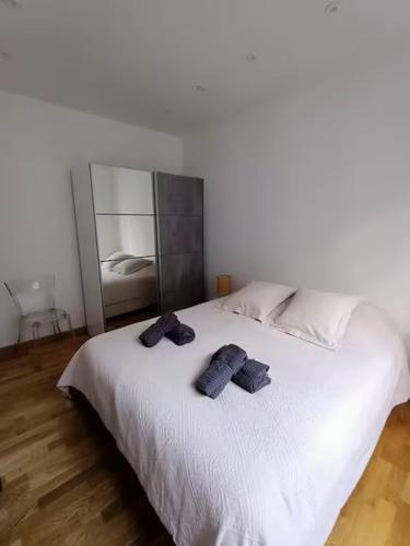 une chambre avec un lit blanc avec deux serviettes dessus dans l'établissement Superbe appartement, aperçu mer, Negresco-centre, à Nice