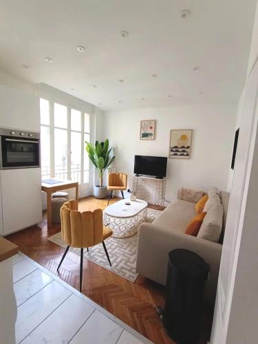 un salon avec un canapé et une table dans l'établissement Superbe appartement, aperçu mer, Negresco-centre, à Nice