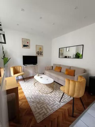 un salon avec un canapé et une table dans l'établissement Superbe appartement, aperçu mer, Negresco-centre, à Nice