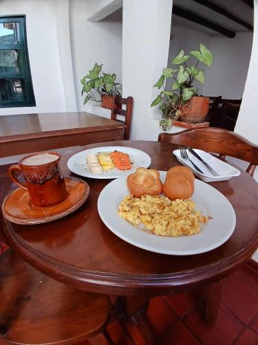 ein Tisch mit Tellern mit Essen und Tassen Kaffee in der Unterkunft HOTEL El CORZO DE LA VILLA in Villa de Leyva