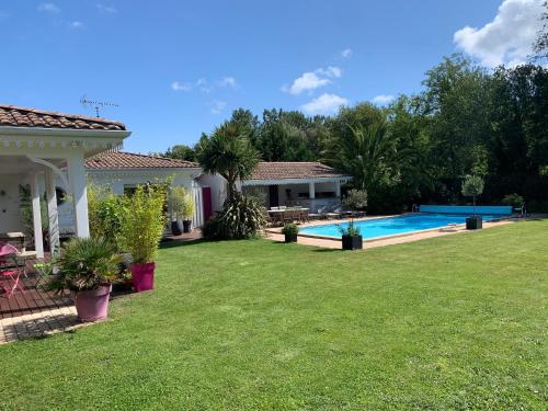 une maison avec une cour et une piscine dans l'établissement Villa du paradis des canards, à La Teste-de-Buch