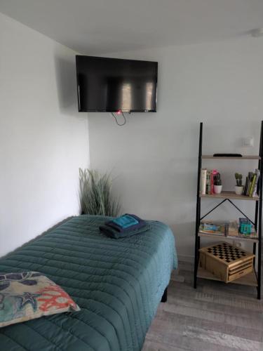 une chambre avec un lit et une télévision à écran plat dans l'établissement Ti Louker - Appartement à 300m du Port, à Locmiquélic