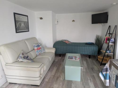 a living room with a couch and a table at Ti Louker - Appartement à 300m du Port in Locmiquélic