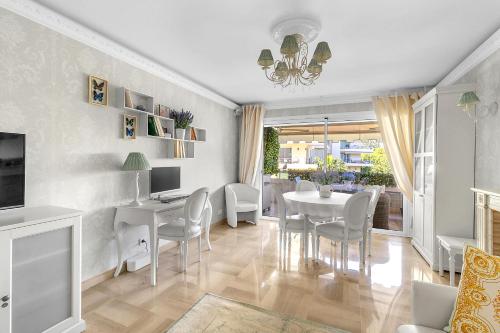 une salle à manger avec une table et des chaises blanches dans l'établissement Appartement CANNES IMPERIAL Pointe Croisette, à Cannes