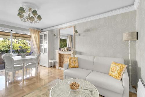 un salon avec un canapé blanc et une table dans l'établissement Appartement CANNES IMPERIAL Pointe Croisette, à Cannes