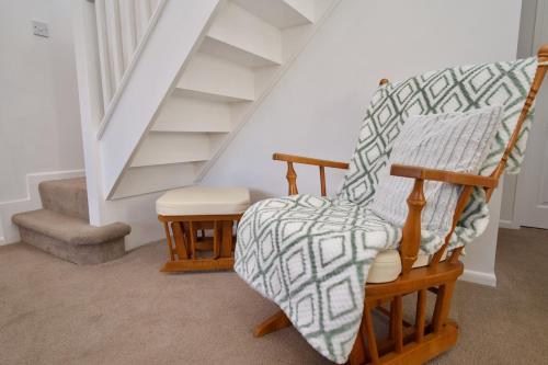 a stair room with a rocking chair and stairs at Natures Lodge Fully Furnished Home Coventry in Coventry
