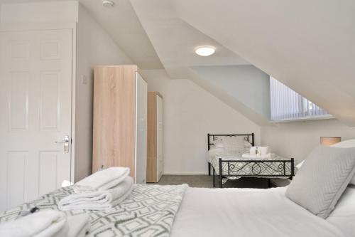 a white bedroom with a bed and a table at Natures Lodge Fully Furnished Home Coventry in Coventry