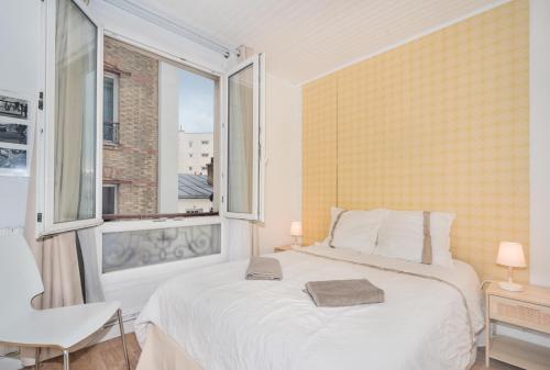 une chambre avec un lit blanc et une fenêtre dans l'établissement Apartment for 6 persons in central Paris, à Paris