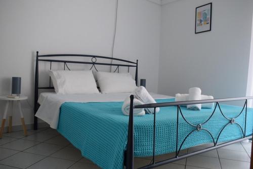 a bedroom with a black bed with a blue blanket at Astros by the sea in Paralion astros