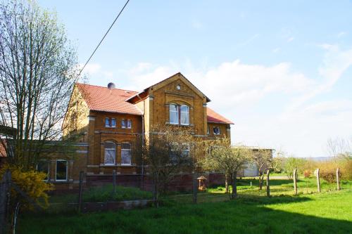 a brick house with a red roof on a green field at Alte Mühle Kelbra - ehemalig ALBIG in Kelbra