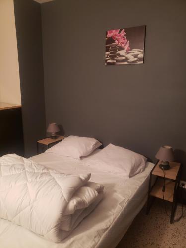 un lit avec des draps blancs et des oreillers dans une chambre dans l'établissement Appartement T2 100 m de la mer, à Argelès-sur-Mer