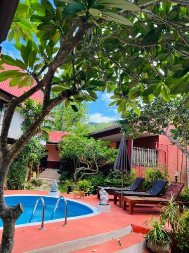 a resort with a swimming pool and a tree at Kantiang Beach Apartments in Ban Ru Yai