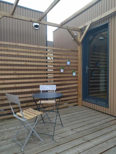 une table et deux chaises sur une terrasse en bois dans l'établissement Au coin des Lilas - Studio 1, au Mans