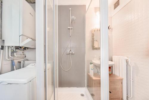une salle de bain blanche avec une douche et un lavabo dans l'établissement Apartment for 6 persons in central Paris, à Paris