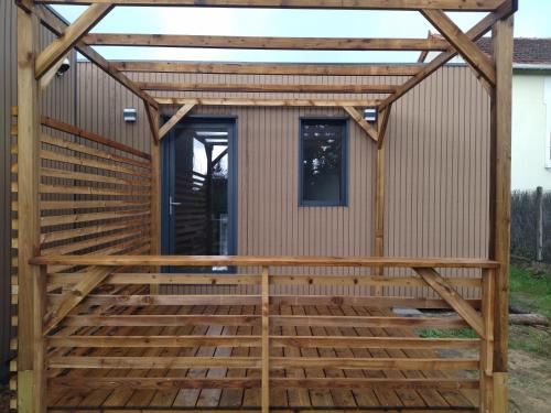 une pergola au-dessus d'une terrasse avec une maison dans l'établissement Au coin des Lilas - Studio 1, au Mans