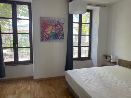 une chambre avec un lit et un tableau au mur dans l'établissement T1 Calme Ajouré et Traversant proche Centre ville, à Millau