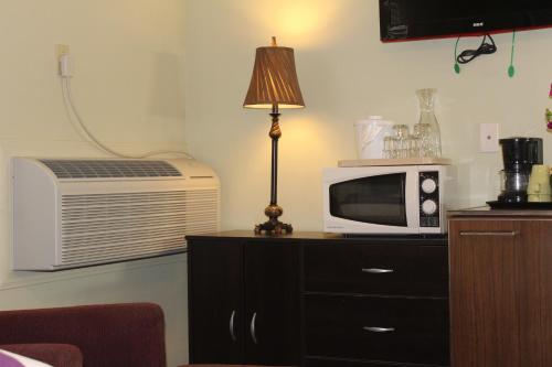 a microwave on a dresser with a lamp and a microwave at El Rancho Motel in Bishop